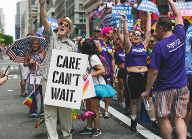 Care can't wait sign held by older gay man