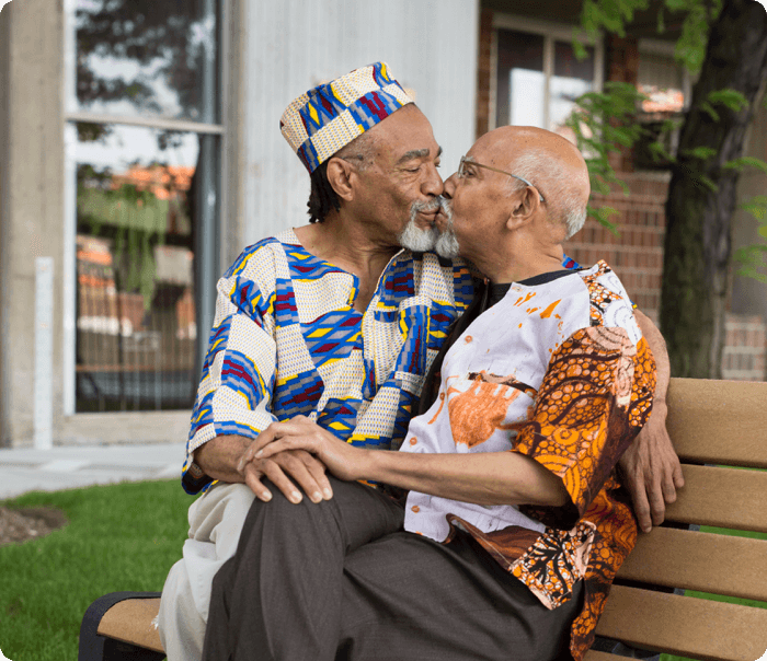 LGBT couple kissing on a bench