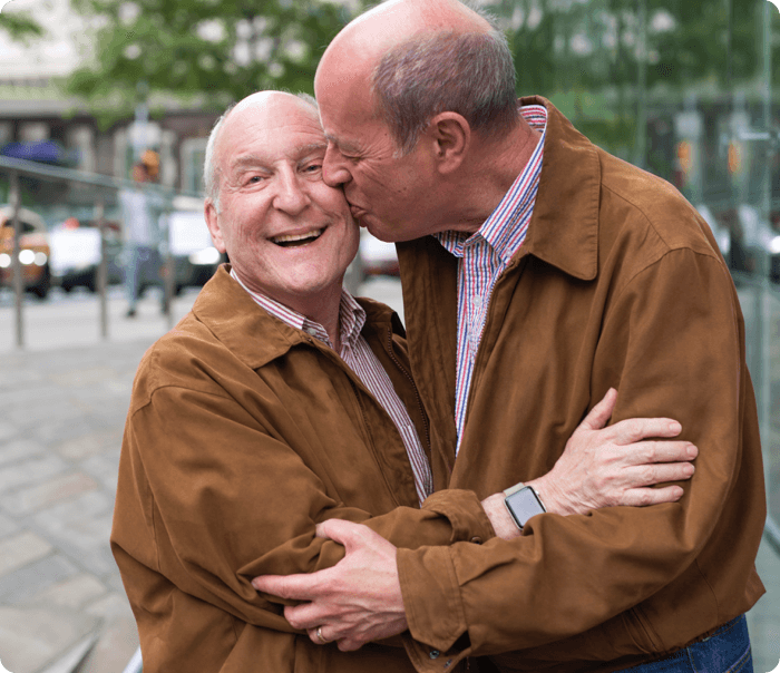 LGBT elder couple embracing in matching jackets