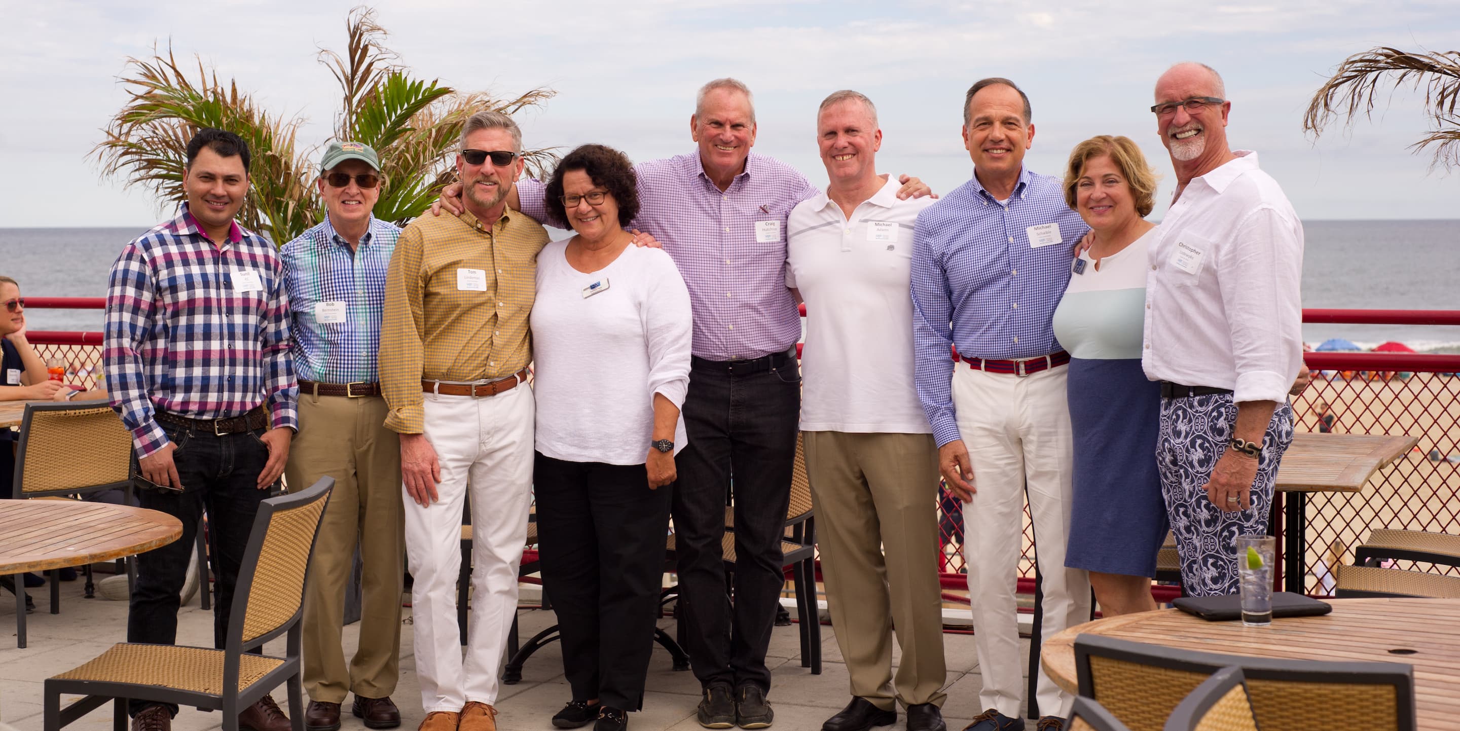 Group of gay and lesbian men and women pose in front of palm trees