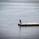 single-person-stands-on-dock