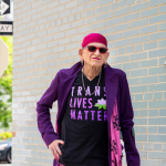 transgender-person-standing-outside-with-cane-and-trans-lives-matter-shirt